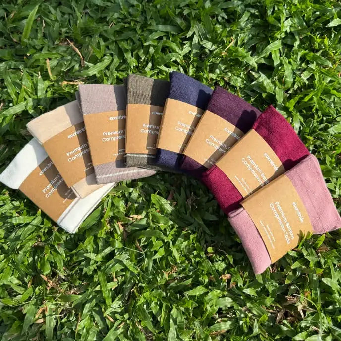 Everstride compression socks in a range of colours laid out on grass